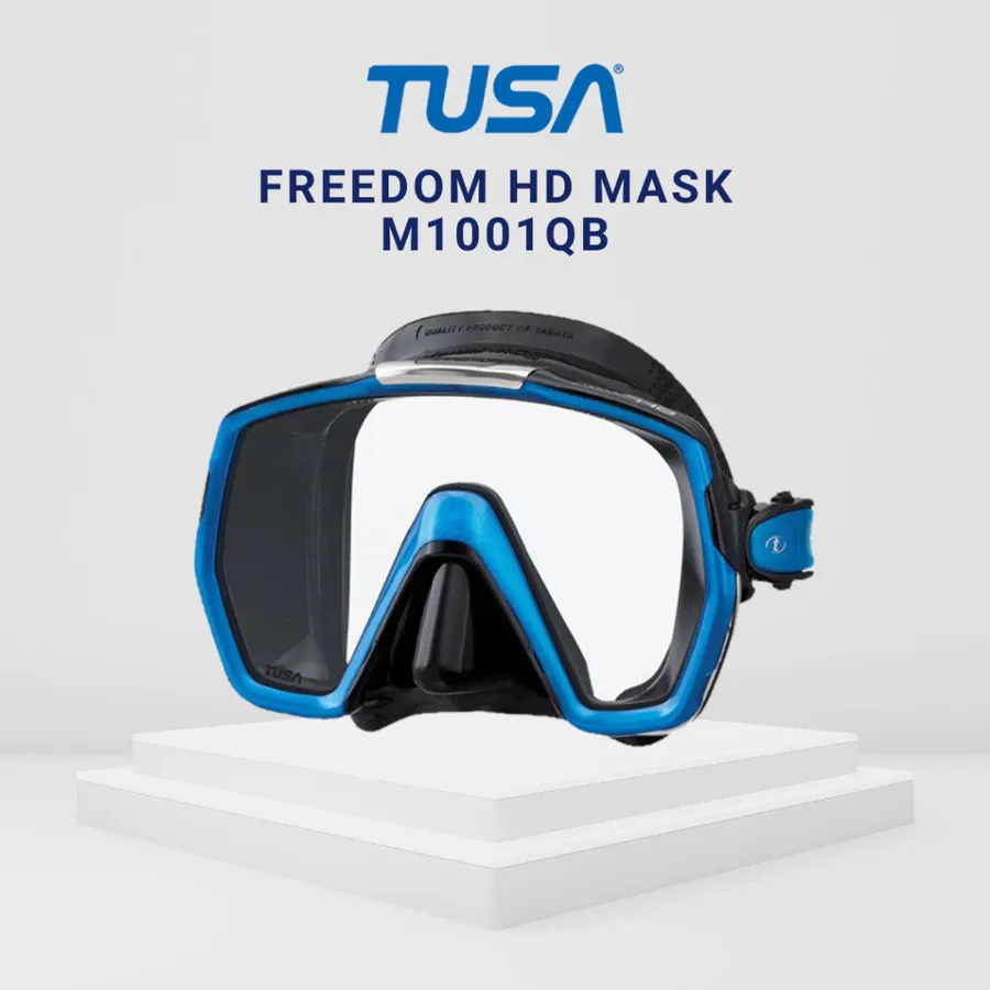 白色台面上的蓝黑色 TUSA Freedom HD M1001QB 面镜，上方显示品牌及型号名称