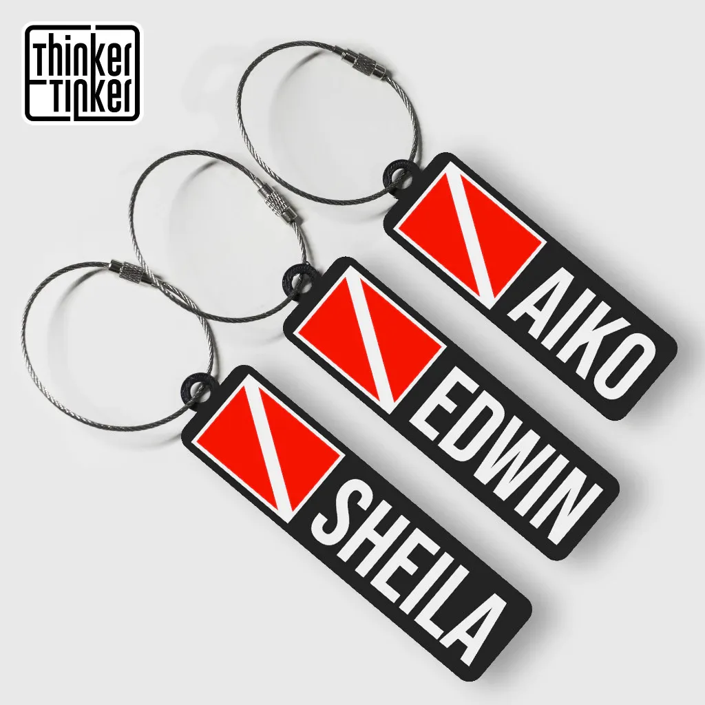 Seller image showing personalised diver-flag bag tags with sample names