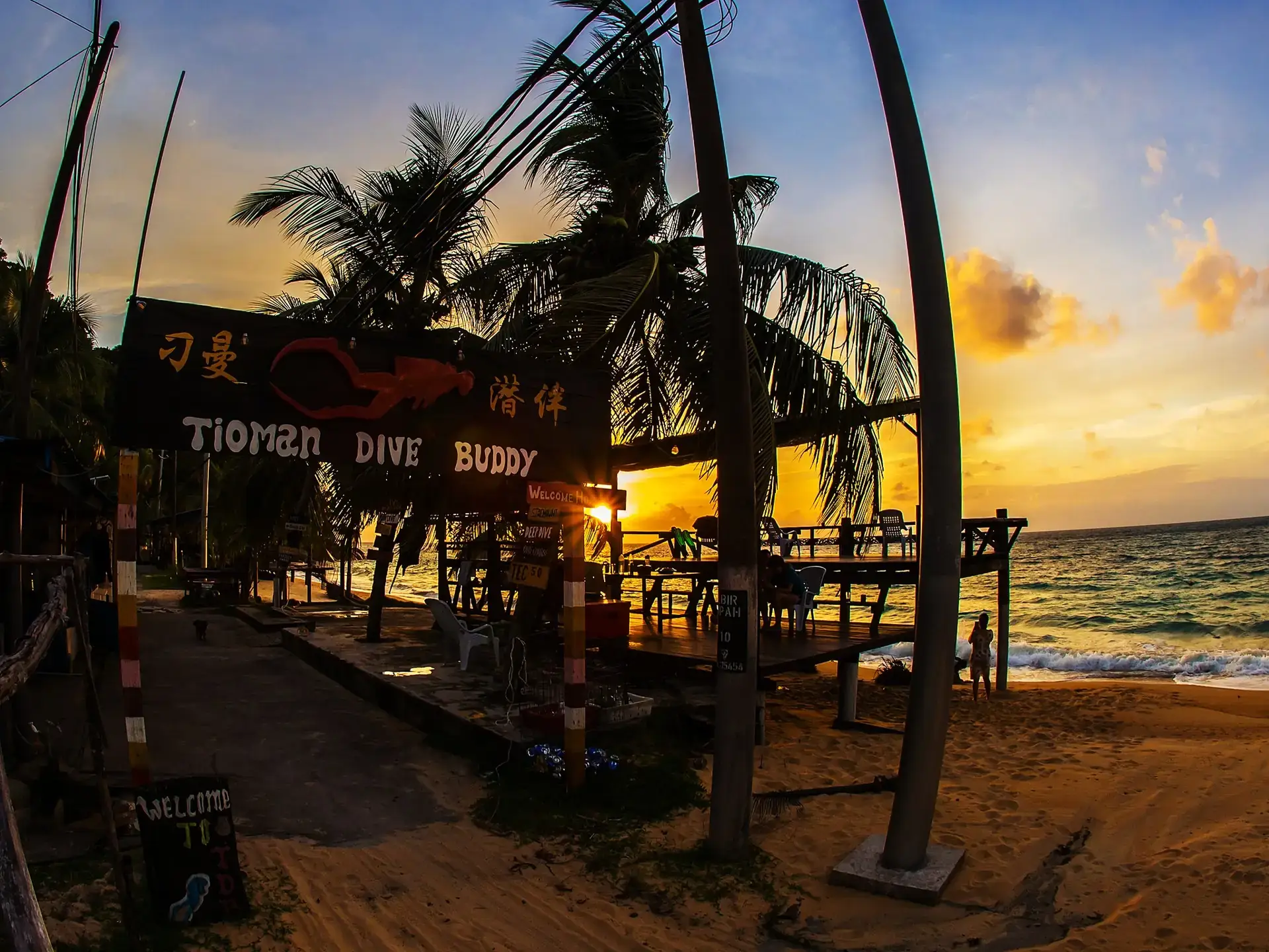 Tioman Dive Buddy centre sign and beachfront deck at sunset.